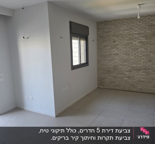 קיר לבנים וחלון בחדר ריק עם רצפת אריחים